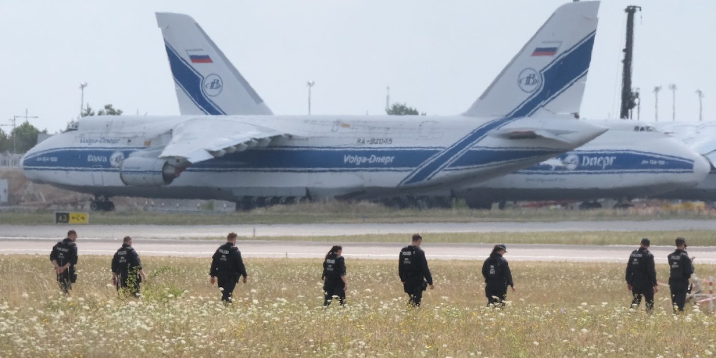 Police officers are walking across a field on the grounds of Leipzig Airport, in Schkeuditz, Germany, Friday, Aug. 7, 2026, searching for a drone that may be connected to a suspected attack. (Sebastian Willnow/dpa via AP)